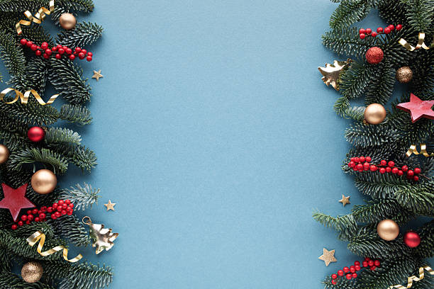 istock Composition of fir branches with red berries and festive bauble on blue background with empty space. Christmas and New Year frame or border. 2248710511