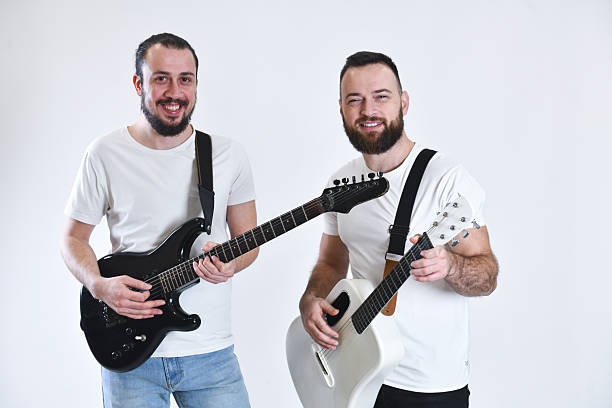 istock Two Bearded Musicians With Guitars Posing Together In White Studio Background, Casual Band Duo 2248711629