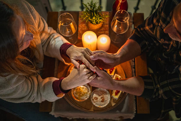 Couple holding hands enjoying romantic candlelight dinner