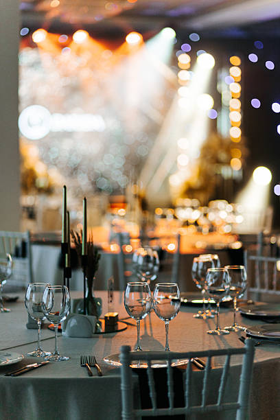 istock Wide view of banquet hall with tables, chairs, and stage lighting 2248714830