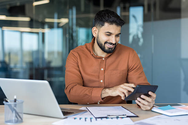 istock Young financial manager calculating budget using calculator in office 2248715116