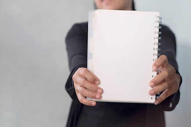 istock women with black outfit presenting a blank document 2248719197