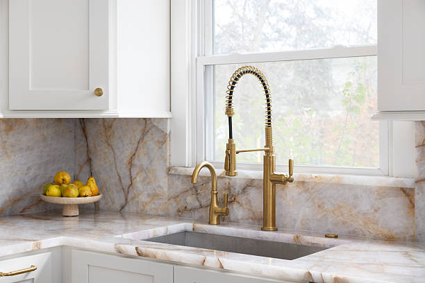 istock A gold kitchen faucet in a white kitchen. 2248720403