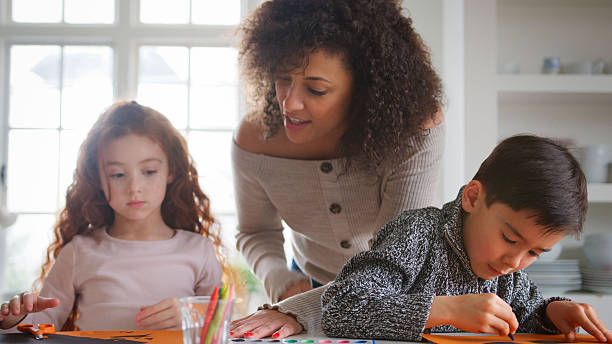 istock Two Children At Home With Mother Having Fun Making Craft Together 2248721520