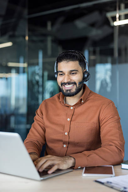 istock Smiling indian man wearing headset typing on laptop 2248722967