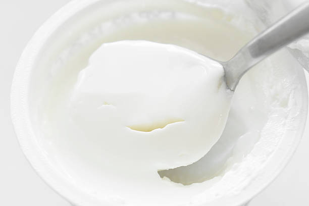 istock Greek yogurt pot with spoon. 2248724872