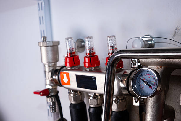 Complex residential heating manifold system with valves, gauges, and piping network.