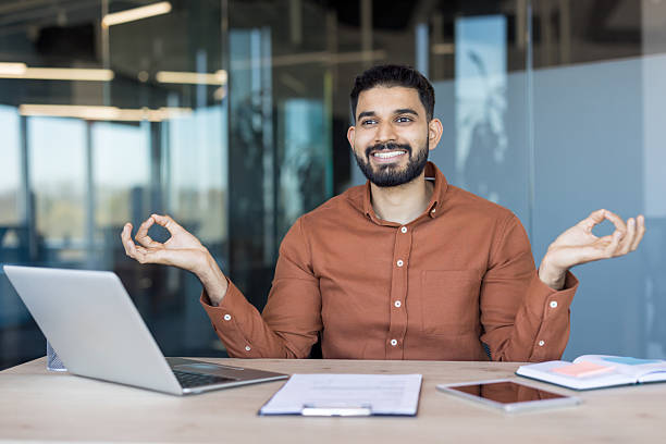istock Young businessman finding calm meditating in modern office 2248729475