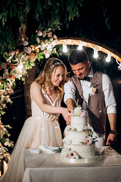 istock newlyweds happily cut and taste the wedding cake 2248730715