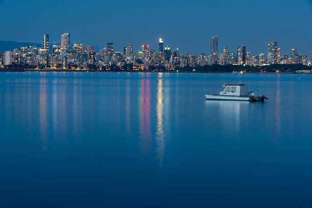 The view of the Vancouver skyline from Jericho Beach on English Bay at dusk. Vancouver, British Columbia, Canada.