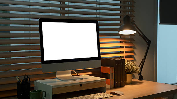 istock Cozy home office with computer, desk lamp, and coffee mug in warm evening light 2248731921