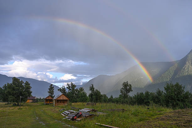 Picturesque double rainbow in the countryside against the backdrop of mountains