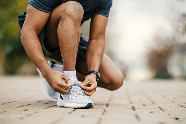istock Man tying shoelace preparing for outdoor run 2248736339