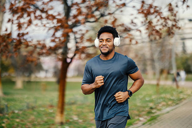 istock Young black man jogging with headphones in park 2248736350