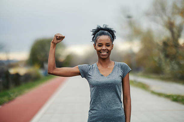 istock Young black woman flexing arm showing strength 2248736633