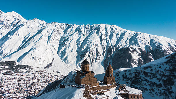 istock Gergeti trinity church perched dramatically on rocky hilltop, revealing dramatic snowy caucasus mountain landscape surrounding historic georgian landmark during winter season 2248739539