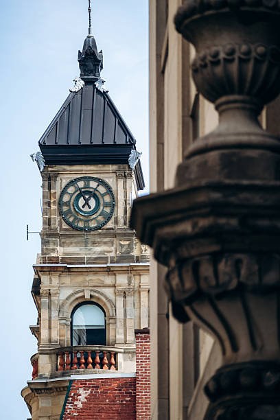 Montreal City Hall clock tower with Roman numerals and architectural detail in foreground