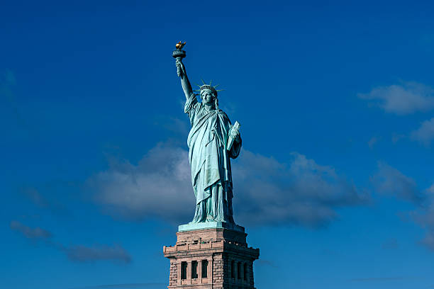 Iconic Statue of Liberty rises on a sturdy pedestal under a clear blue sky, embodying freedom and New York City’s enduring spirit in bright daylight.