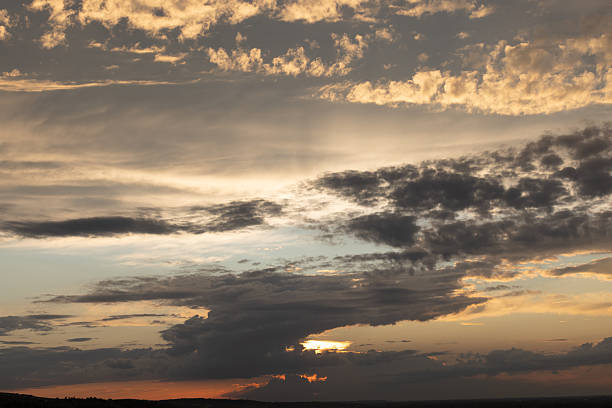 A tranquil dusk scene shows a vast sky filled with warm clouds and a glowing horizon, conveying calmness and natural beauty. Perfect for nature, sunset, and serene landscape themes.