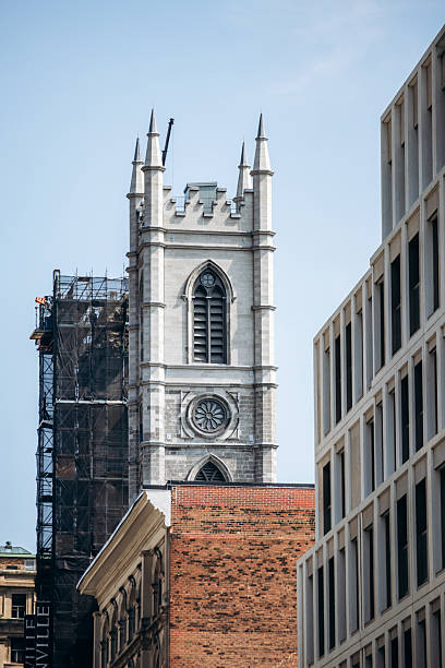 Montreal, Canada - August 14, 2025: downtown view with Notre-Dame Basilica stone tower and surrounding modern buildings
