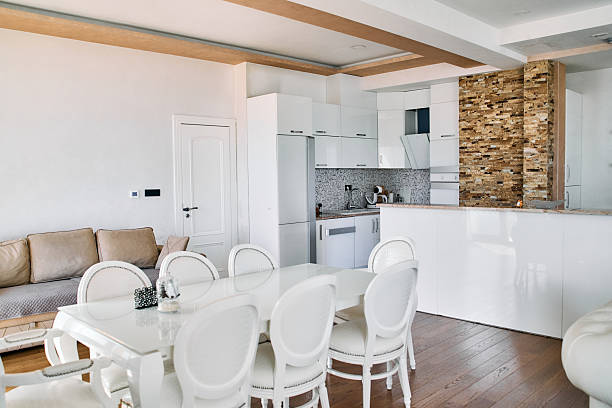A bright kitchen with wooden cabinets and a dining table in a modern luxury villa.