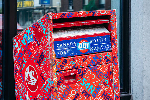 Montreal, Canada  August 15, 2025: Canada Post mailbox covered with colorful stickers in downtown Montreal
