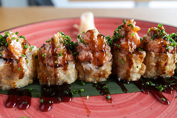 Delicious japanese fried sushi rolls with spicy salmon and teriyaki sauce