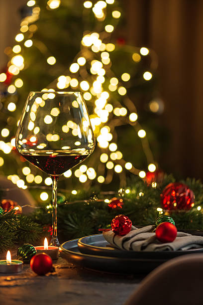 istock Christmas Table Setting with Wineglasses with Red Wine against Christmas lights 2248749657