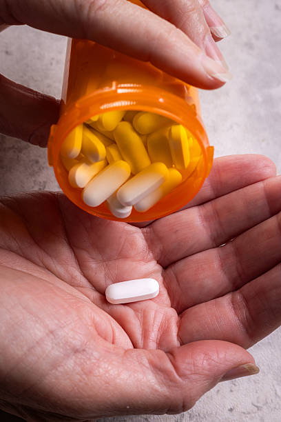 istock Hand Dispensing Pills with Multiple Bottles: Chronic Illness, Polypharmacy, and the High Cost of Long-Term Care 2248750336
