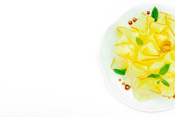 istock Thinly sliced melon carpaccio appetizer with fresh mint and balsamic sauce drops on a white plate 2248753354