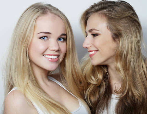 istock Two young girl friends standing together and having fun. 2248755904