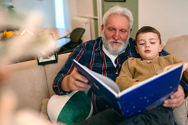 istock Grandpa and grandson reading book togethe 2248759536