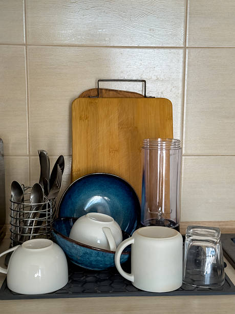 istock Freshly washed dishes drying on a kitchen counter with cups, bowls, utensils, and cutting boards. 2248761235