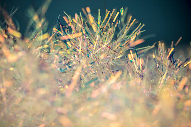 Bright tinsel strands shimmer in a mix of colors, creating a vibrant scene. Space for copy.