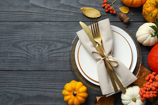 istock A beautifully decorated holiday table setting with an napkin, decorative pumpkins, fall leaves, festive atmosphere. 2248763095
