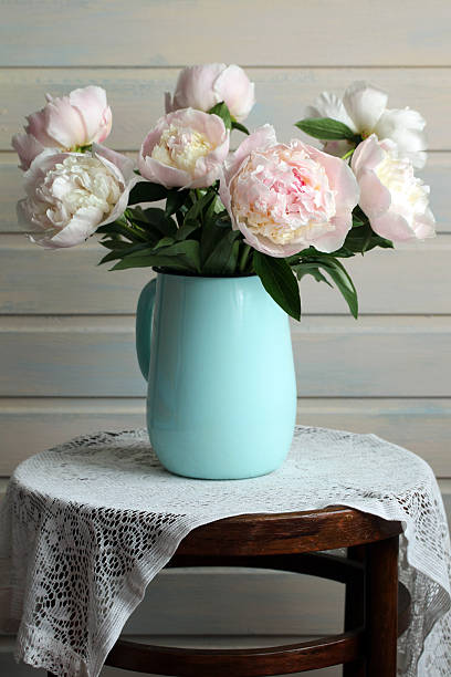 istock Peony bouquet in turquoise vase on a lace tablecloth 2248765515