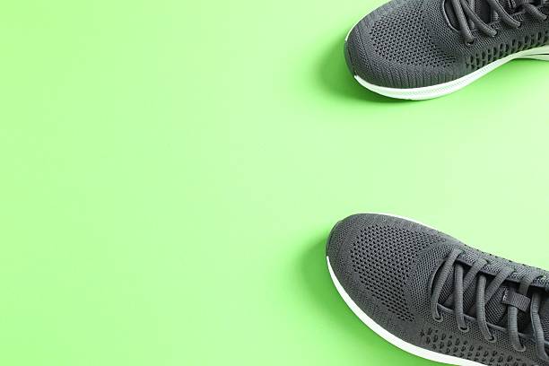 istock Black sneakers on green background 2248765734