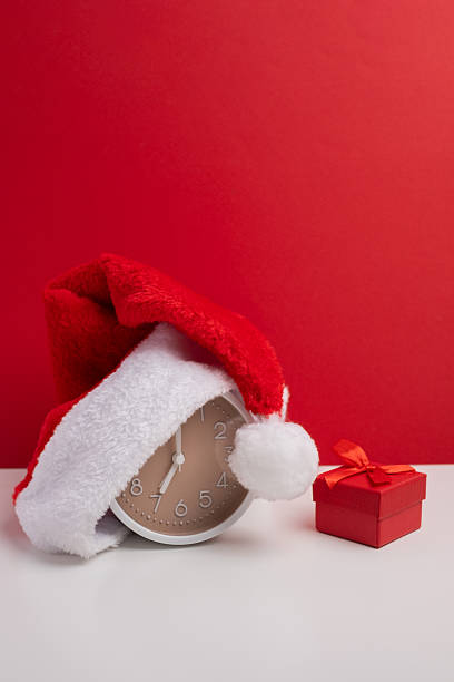 istock Santa hat concealing present on soft color background. Surprise christmas gift. 2248769950