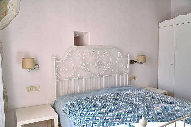 istock Cozy Bedroom Featuring Elegant White Metal Bedframe with Decorative Bedding and Soft Lighting in a Warm Pastel-Hued Setting 2248771275