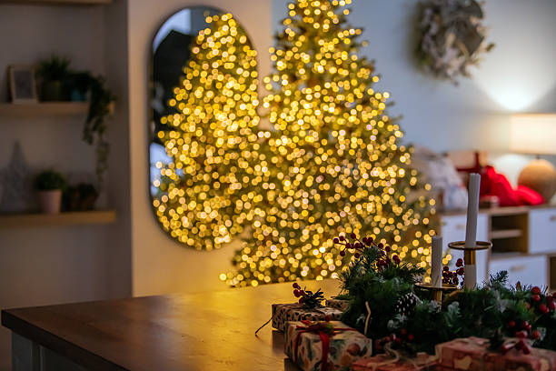 istock Warm Christmas setting with decorated table, wrapped gifts, and blurry festive lights. Cozy holiday background 2248774633