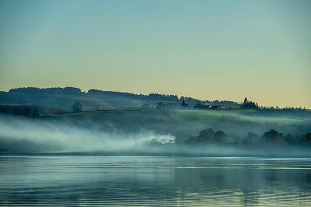 An evening mist over the water and the shore of the Loch Lomond in the Loch Lomond and the Trossachs National Park