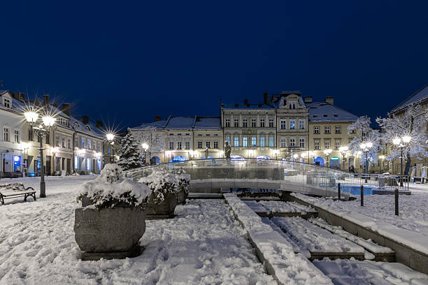 istock Snowy Town Square at Night with Illuminated Old Buildings 2248776014