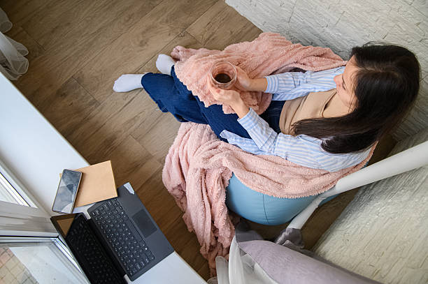 istock Cozy Home Lifestyle: Woman Reading and Relaxing by the Window 2248778806