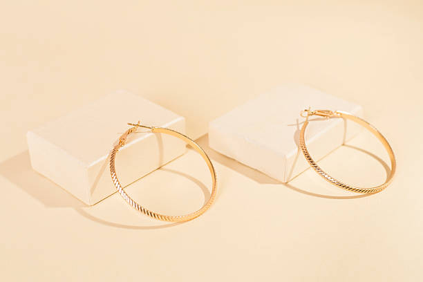 istock Golden earrings with decor on color background 2248779192