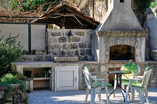 istock Charming Outdoor Cooking Space Featuring Rustic Stone Grill, Cozy Seating Area, and Lush Greenery Perfect for Entertaining and Relaxation 2248780692