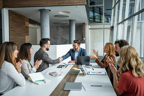istock Business meeting ending with handshake and colleagues applauding 2248787553