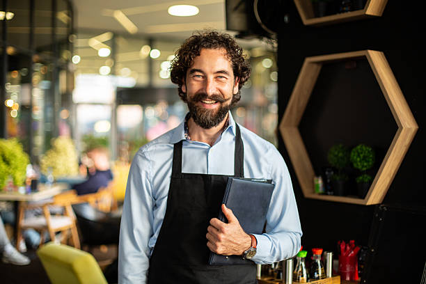 istock Waiter smiling in restaurant holding menu concept 2248794479
