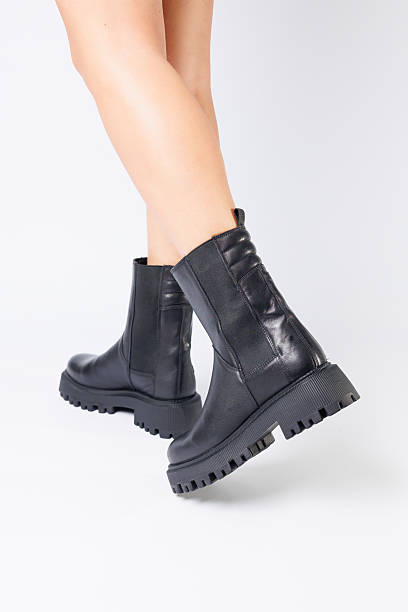 istock Women's black spring boots made of genuine leather are dressed on bare feet 2248795539