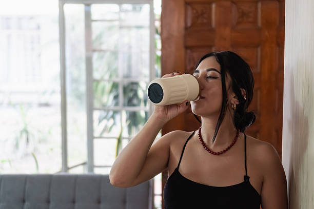 istock Woman drinking hot beverage from mug at home 2248795688