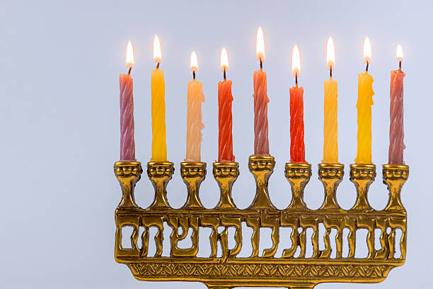 Glowing Hanukkah candles glow on menorah, creating warm atmosphere during Jewish festive event celebrating traditions.